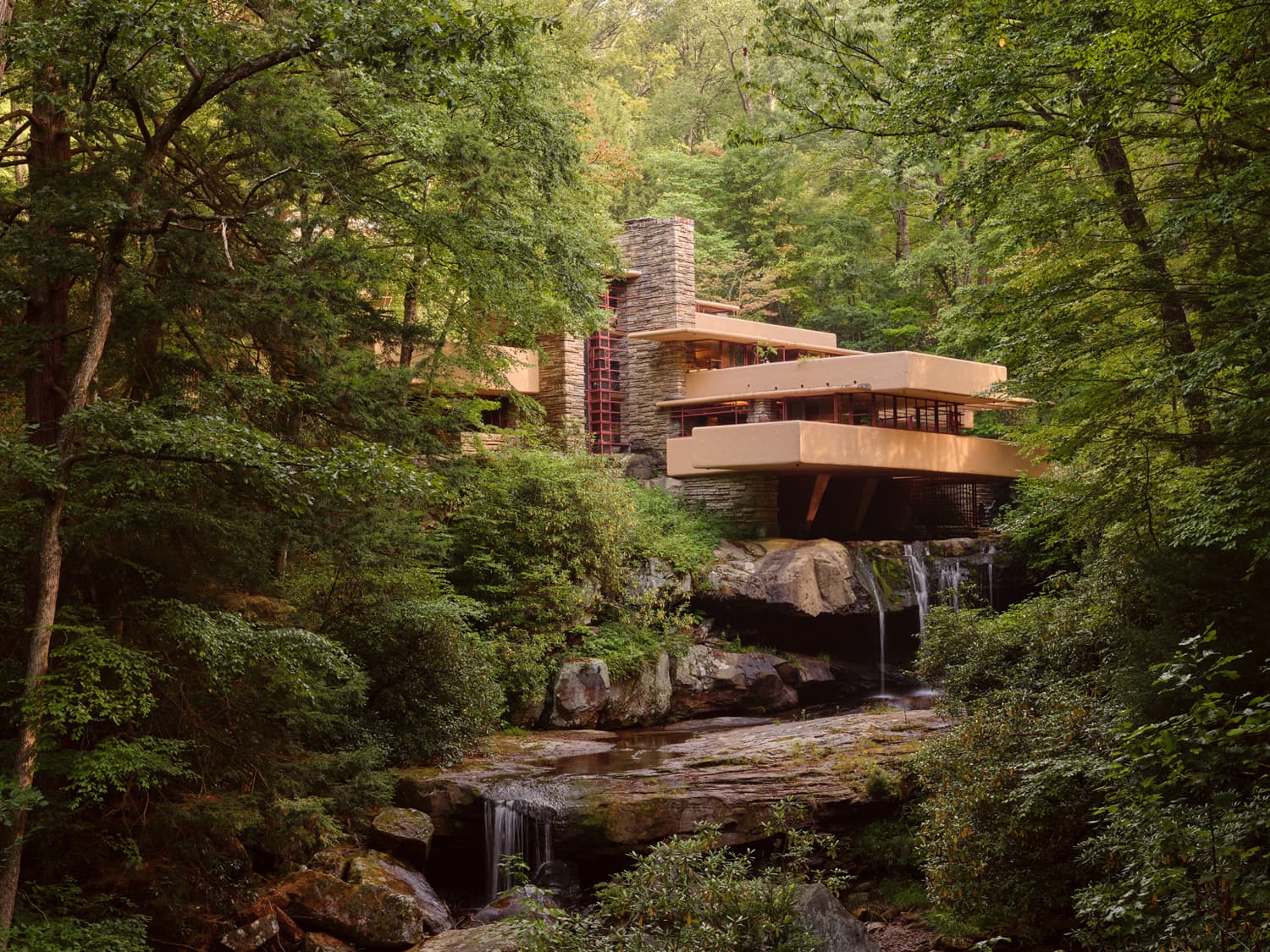 Fallingwater exterior framed by forest with cantilevered terraces over Bear Run waterfall