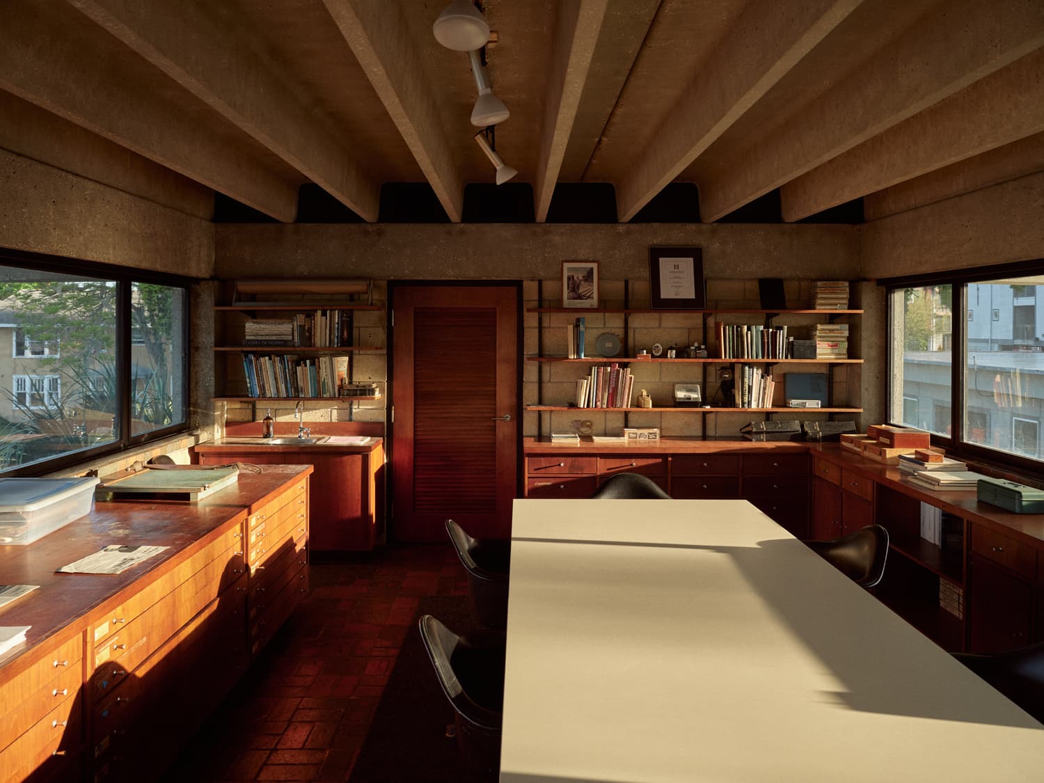 Full view of Strang Design Office with exposed concrete beams, drafting cabinets, and work table